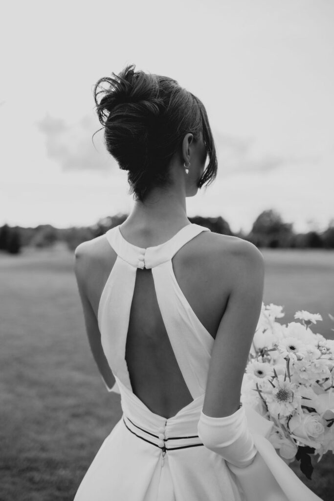 Braut, Blick von hinten auf das Brautkleid, die Frisur und ihren Brautstrauß